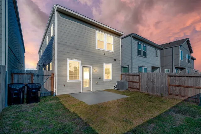 a view of a house with backyard and wooden fence