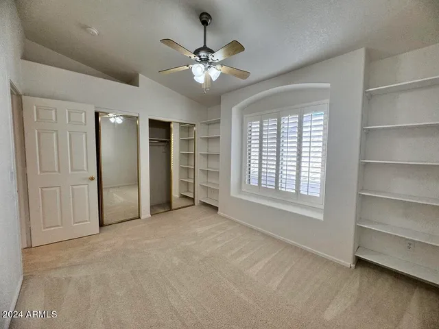a view of a hallway with wooden shelves