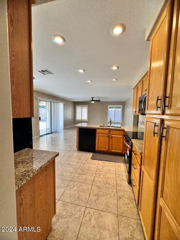 a large kitchen with stainless steel appliances granite countertop a sink and cabinets