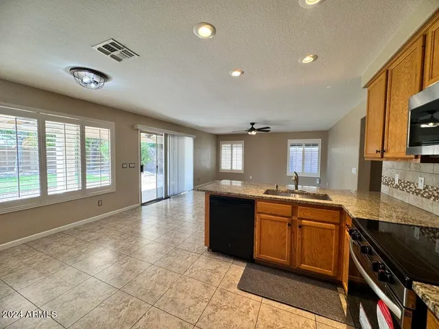 a kitchen with granite countertop a refrigerator and a stove top oven