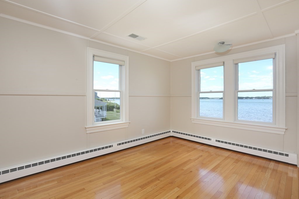 11 Bryant Road Bourne, MA 02532 - Photo 19 of 28 an empty room with wooden floor and windows