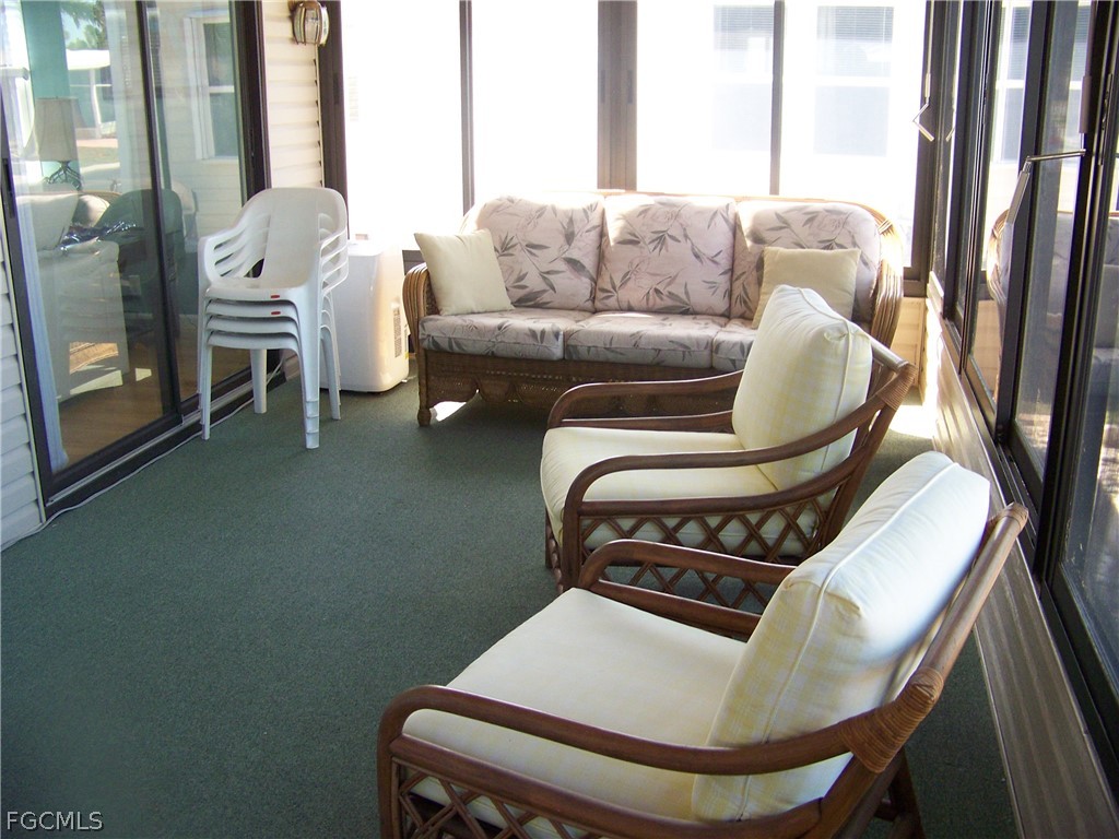 15550 Burnt Store Road, Unit 72 Punta Gorda, FL 33955 - Photo 12 of 50 a living room with furniture and a floor to ceiling window