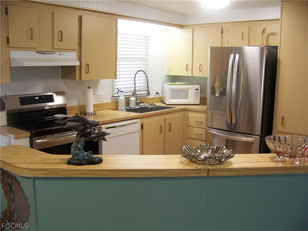 15550 Burnt Store Road, Unit 72 Punta Gorda, FL 33955 - Photo 15 of 50 a kitchen with a sink stove and refrigerator