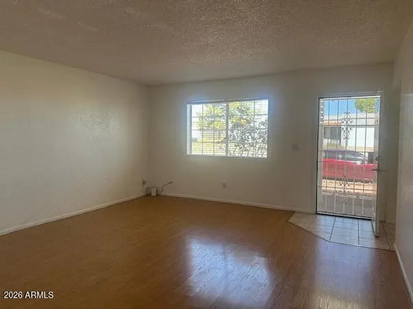 an empty room with wooden floor and windows