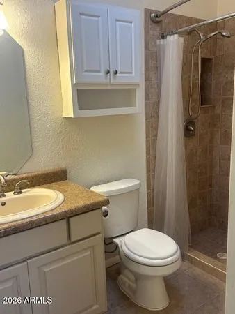 a bathroom with a granite countertop sink toilet and shower