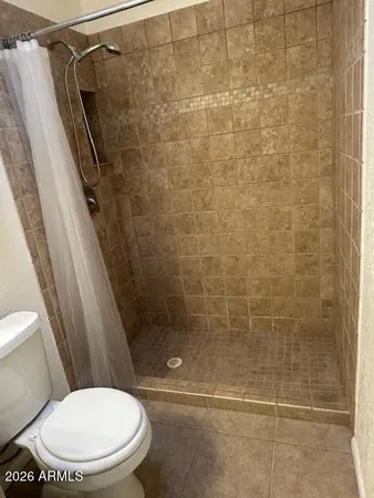 a bathroom with a toilet and a shower