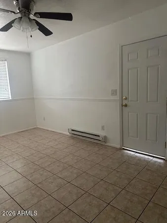 a view of an empty room and chandelier fan