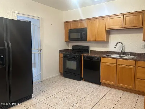 a kitchen with stainless steel appliances granite countertop a refrigerator stove top oven and sink