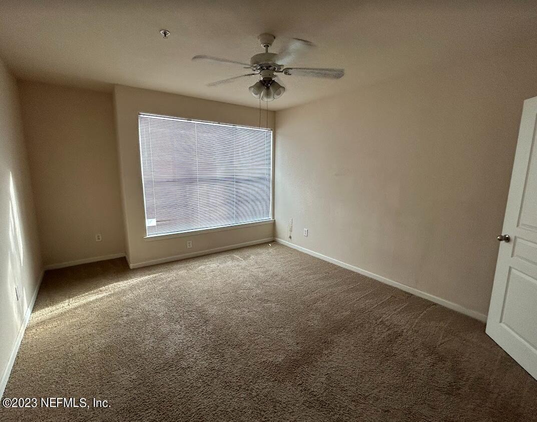 8290 Gate Parkway West, Unit 149 Jacksonville, FL 32216 - Photo 12 of 14 an empty room with a ceiling fan and a window