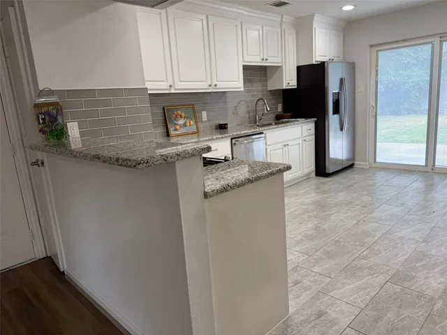 a kitchen with stainless steel appliances granite countertop a refrigerator sink and cabinets