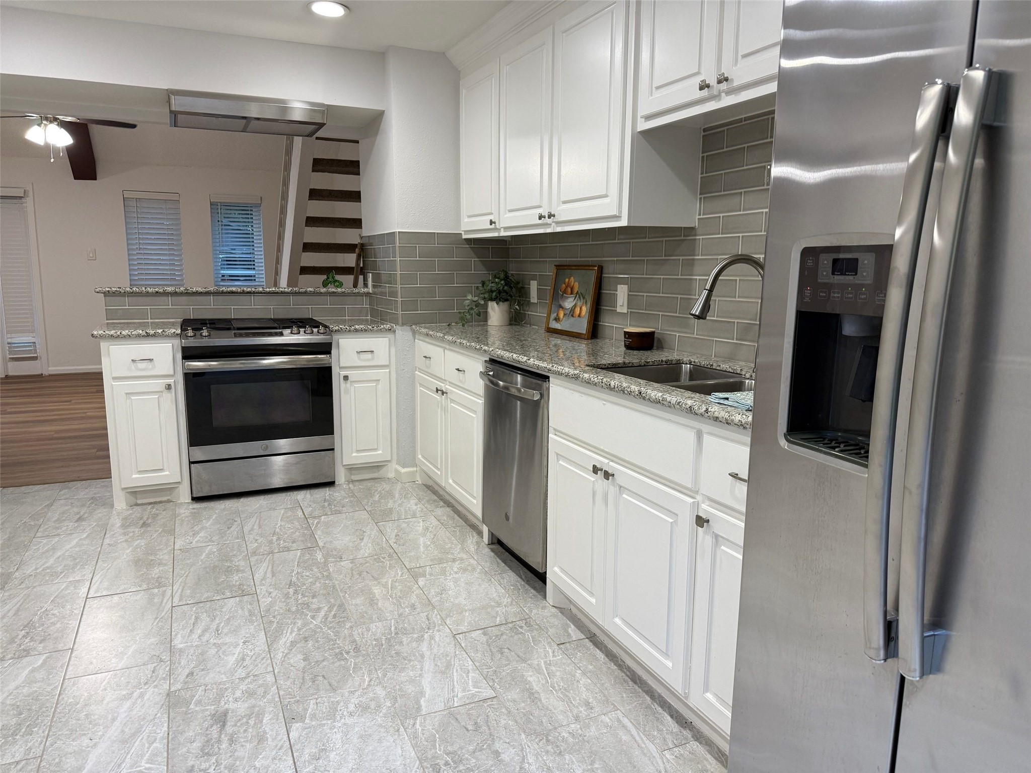 9626 Magnolia Ridge Drive Houston, TX 77070 - Photo 14 of 40 a kitchen with stainless steel appliances granite countertop a stove a sink and a microwave