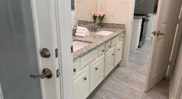 a bathroom with a granite countertop sink and a mirror