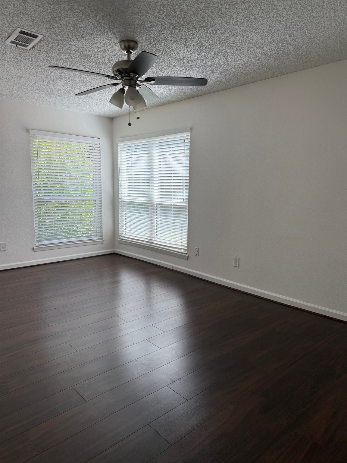 9626 Magnolia Ridge Drive Houston, TX 77070 - Photo 25 of 40 an empty room with wooden floor chandelier fan and windows