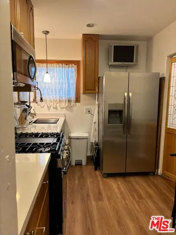 a kitchen with a sink a refrigerator and a stove top oven