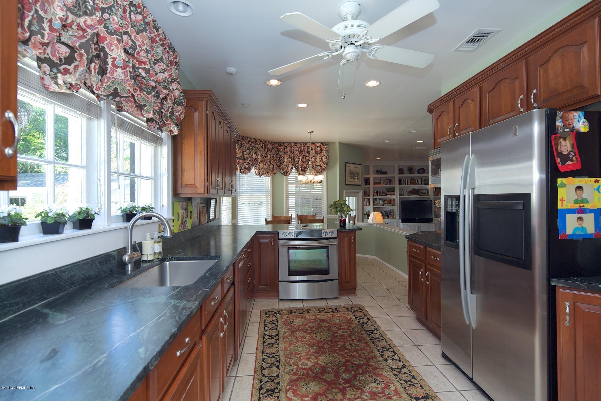 1138 Greenridge Road Jacksonville, FL 32207 - Photo 12 of 36 a kitchen with stainless steel appliances granite countertop a refrigerator a oven a sink with wooden cabinets and wooden floor