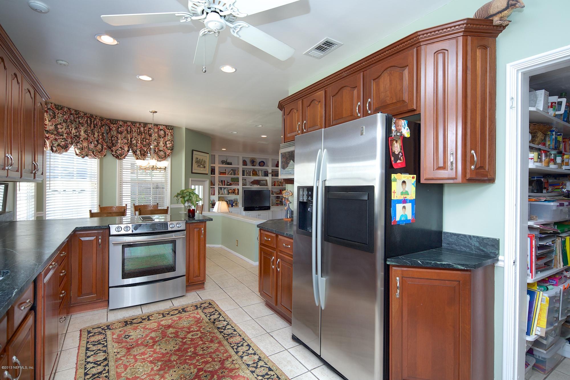 1138 Greenridge Road Jacksonville, FL 32207 - Photo 13 of 36 a kitchen with stainless steel appliances granite countertop a refrigerator a stove and a sink with wooden floor