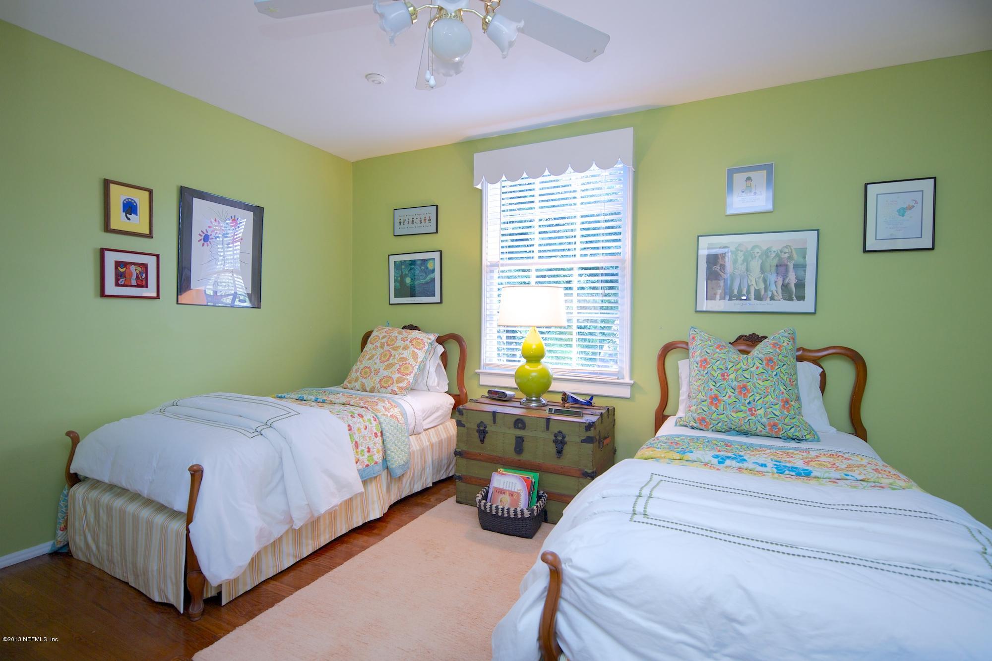 1138 Greenridge Road Jacksonville, FL 32207 - Photo 25 of 36 a bedroom with a bed and a chandelier