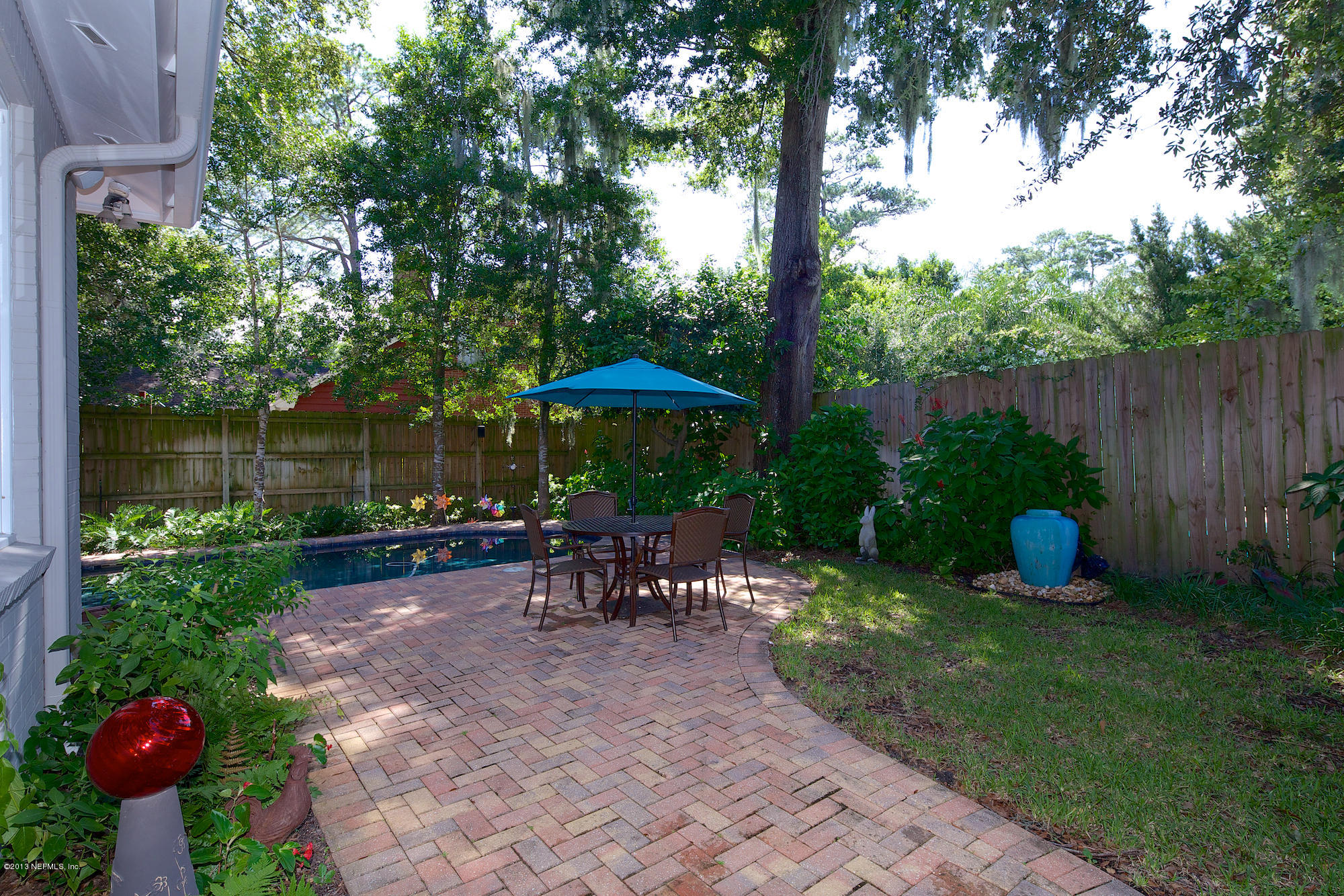 1138 Greenridge Road Jacksonville, FL 32207 - Photo 34 of 36 a view of a backyard with table and chairs potted plants and a fire pit