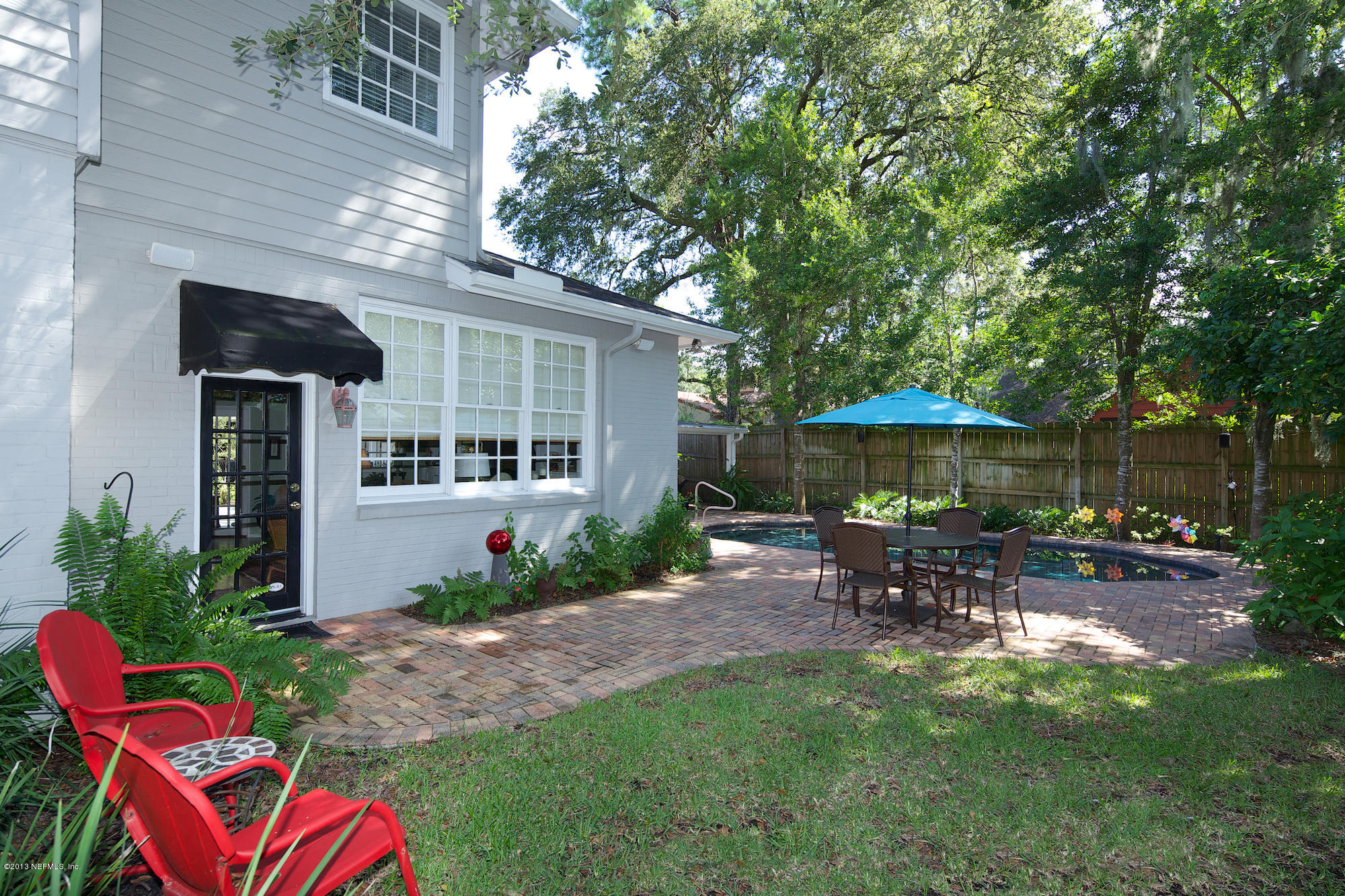 1138 Greenridge Road Jacksonville, FL 32207 - Photo 35 of 36 a backyard of a house with table and chairs under an umbrella