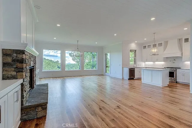 a kitchen with stainless steel appliances granite countertop a refrigerator a stove and a wooden floors