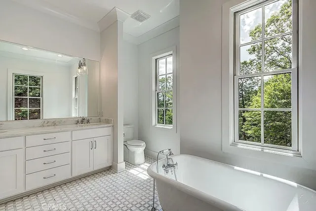 a bathroom with a granite countertop sink a mirror and a bathtub