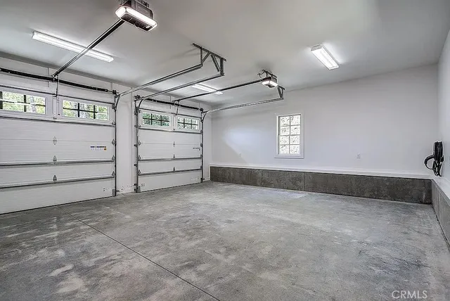 a view of an empty room with a window and a kitchen