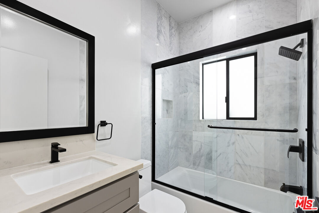 7229 Willoughby Avenue, Unit 8 Los Angeles, CA 90046 - Photo 11 of 14 a bathroom with a sink toilet a mirror and shower