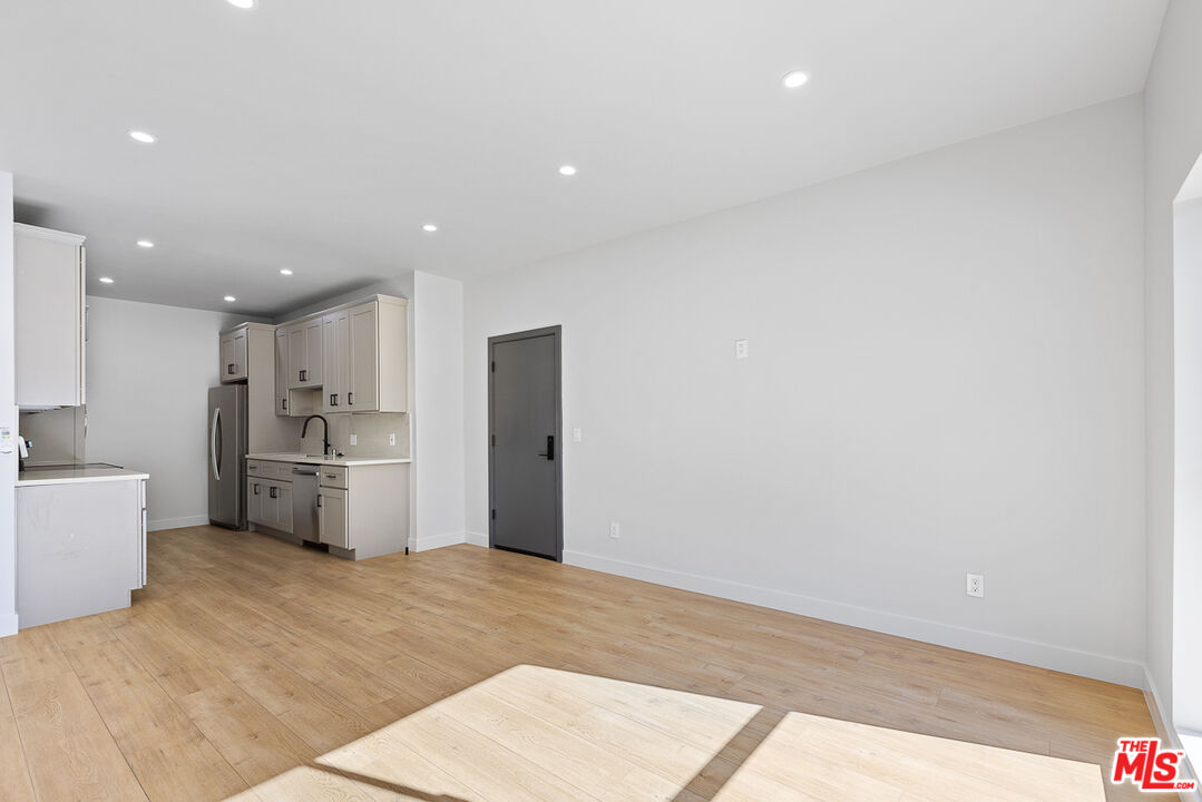 7229 Willoughby Avenue, Unit 8 Los Angeles, CA 90046 - Photo 3 of 14 a kitchen with a refrigerator and wooden floor