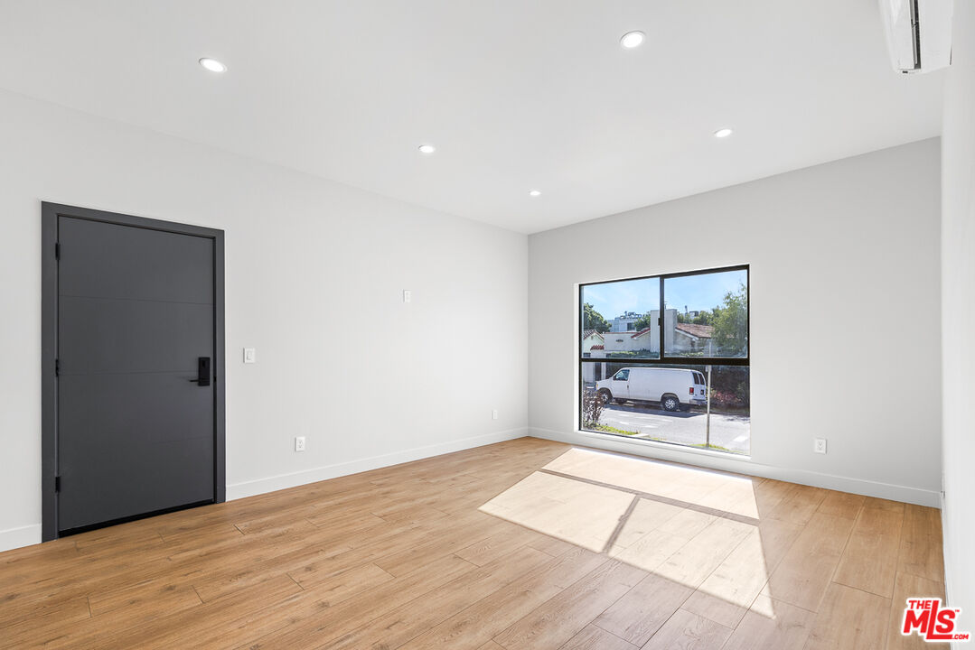 7229 Willoughby Avenue, Unit 8 Los Angeles, CA 90046 - Photo 4 of 14 a big room with wooden floor fireplace and windows