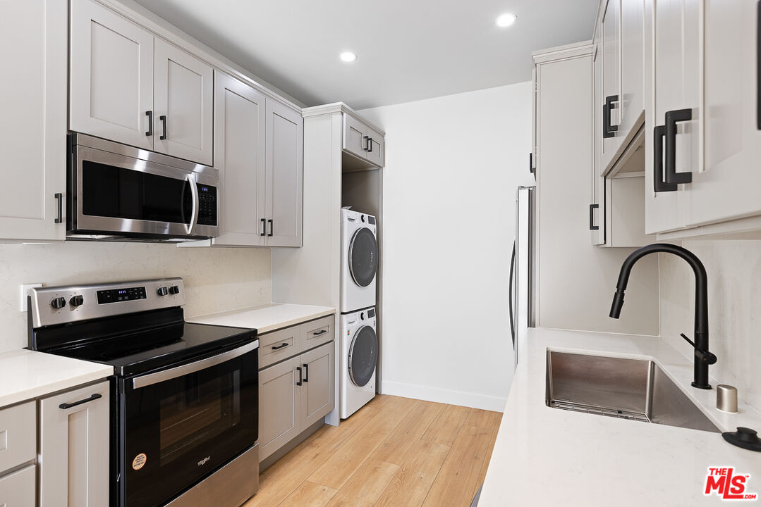7229 Willoughby Avenue, Unit 8 Los Angeles, CA 90046 - Photo 5 of 14 a kitchen with stainless steel appliances a stove microwave and a sink