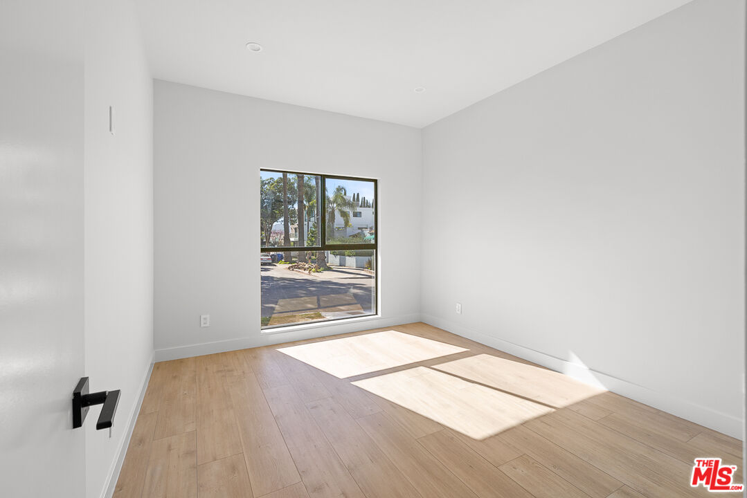 7229 Willoughby Avenue, Unit 8 Los Angeles, CA 90046 - Photo 8 of 14 an empty room with wooden floor and windows