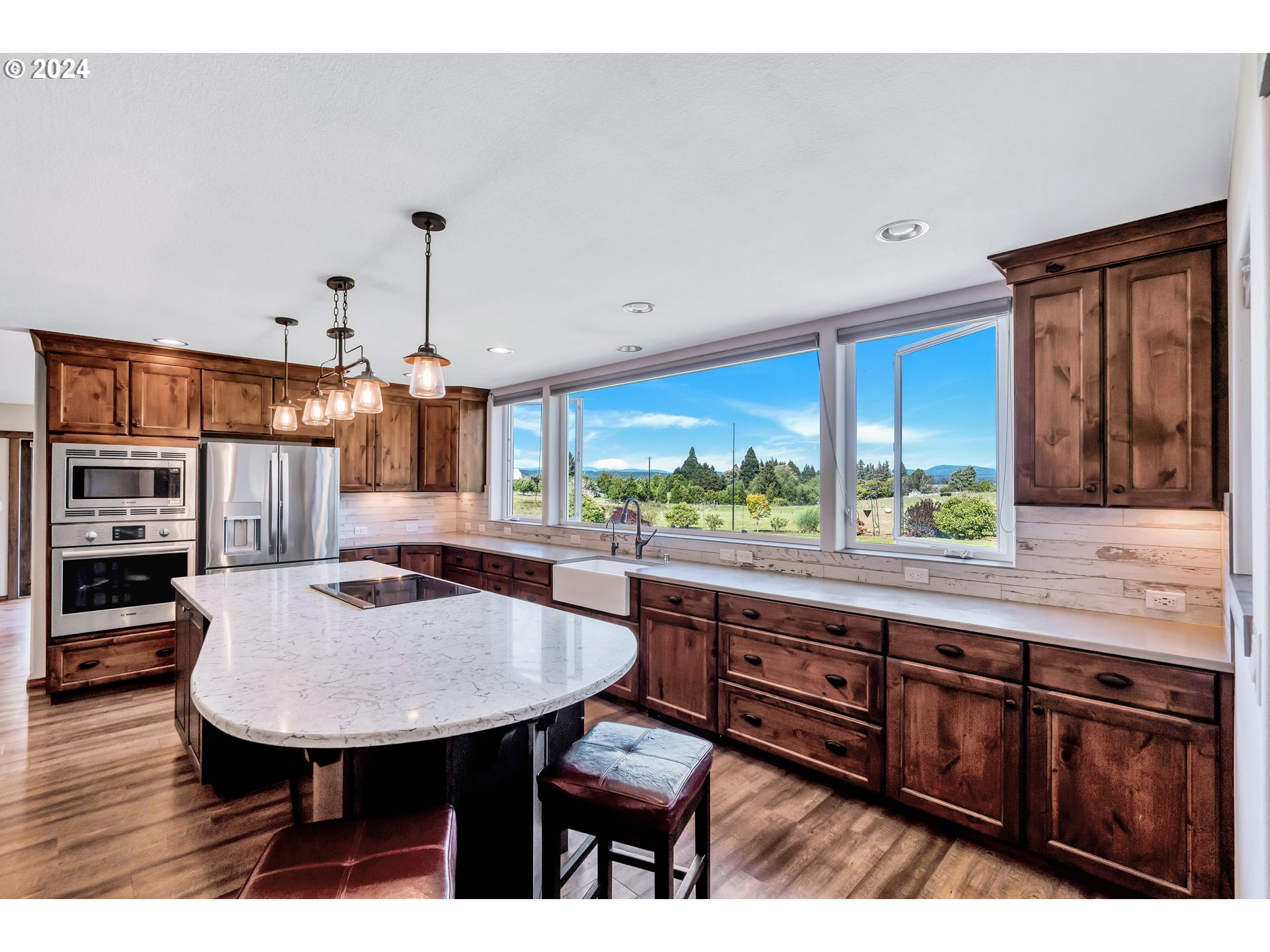 26400 Northeast 29th Avenue Ridgefield, WA 98642 - Photo 11 of 48 a room with stainless steel appliances kitchen island granite countertop a table chairs and a wooden floor