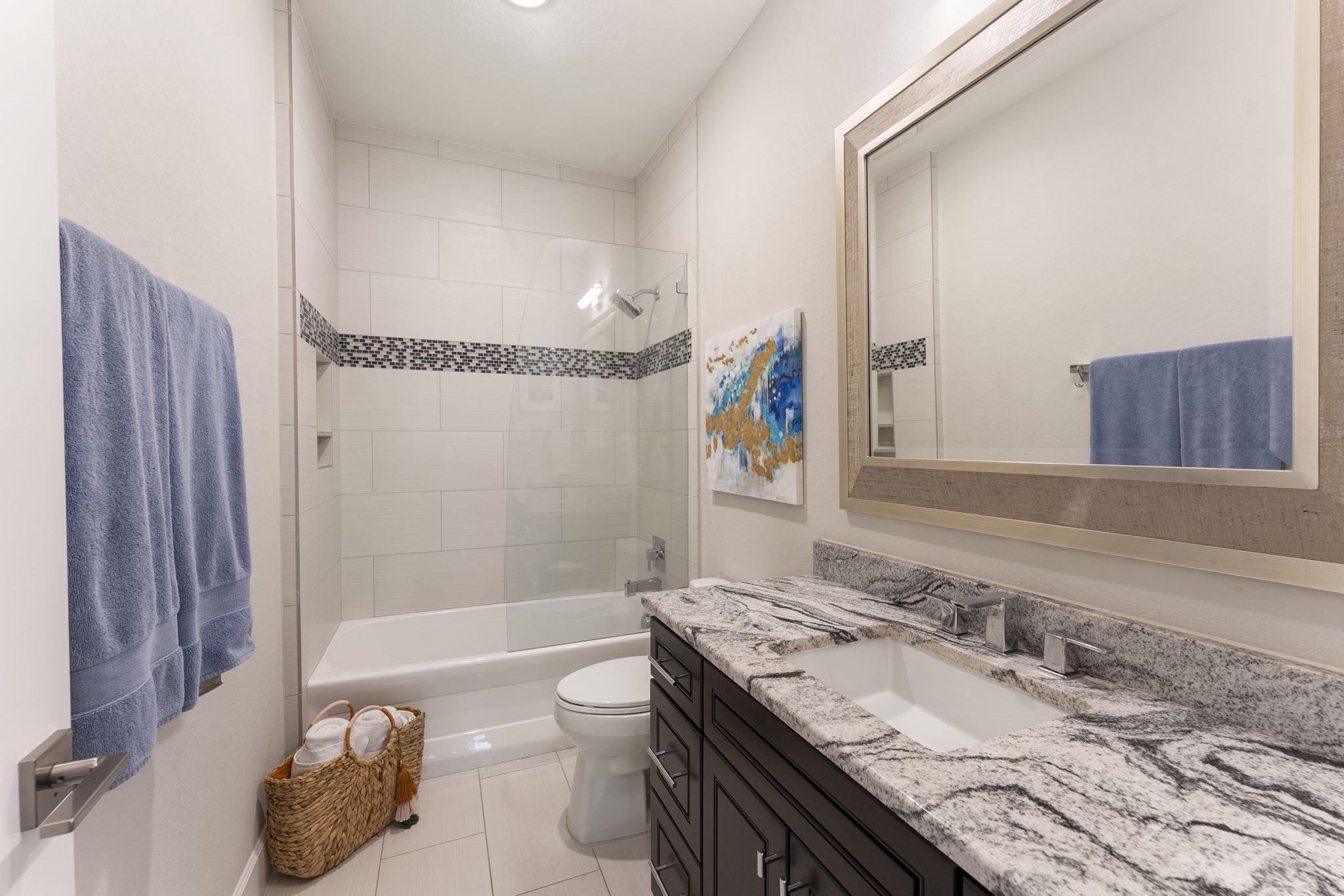 25607 Muirfield Bend Court Spring, TX 77389 - Photo 22 of 30 Well-appointed secondary bathroom featuring granite countertops, rich cabinetry, and a tiled tub/shower combination with decorative accent detailing—offering both style and functionality for family and guests.