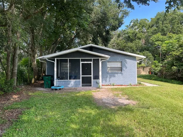 a front view of a house with a yard and trees