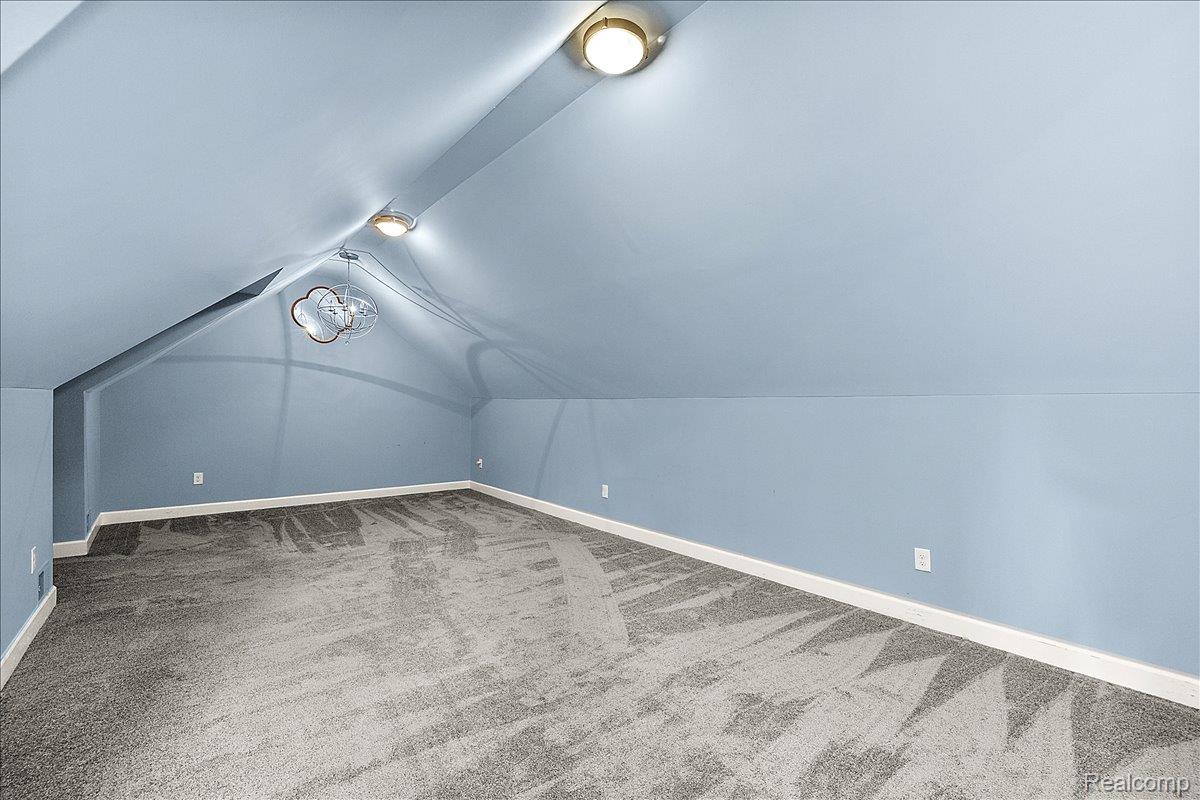 1051 Devonshire Road Grosse Pointe, MI 48230 - Photo 56 of 99 Spacious room featuring sloped ceilings, two flush-mount ceiling lights, and a decorative pendant light