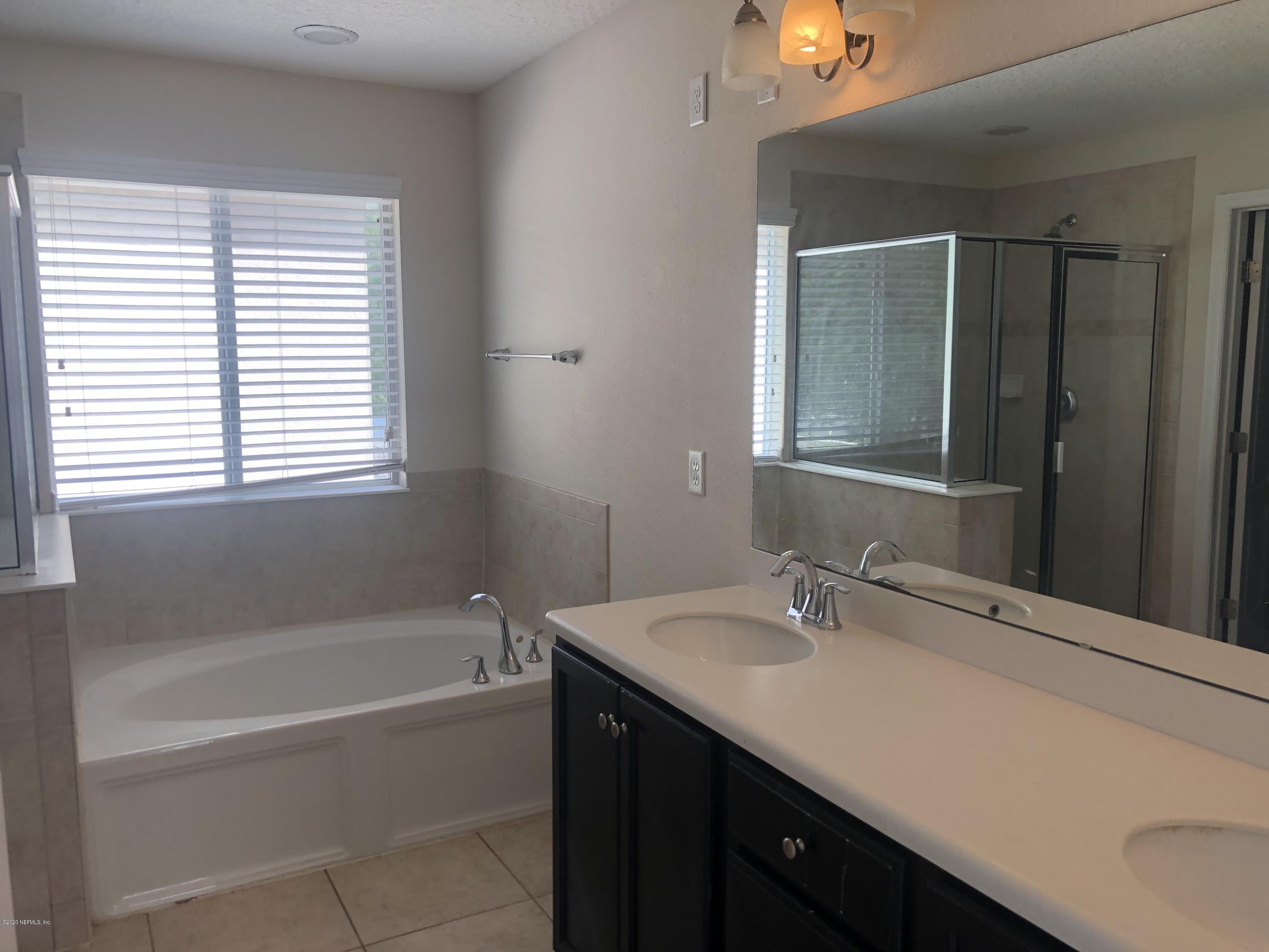3782 Chasing Falls Road Orange Park, FL 32065 - Photo 13 of 22 a bathroom with a bathtub sink vanity and a mirror