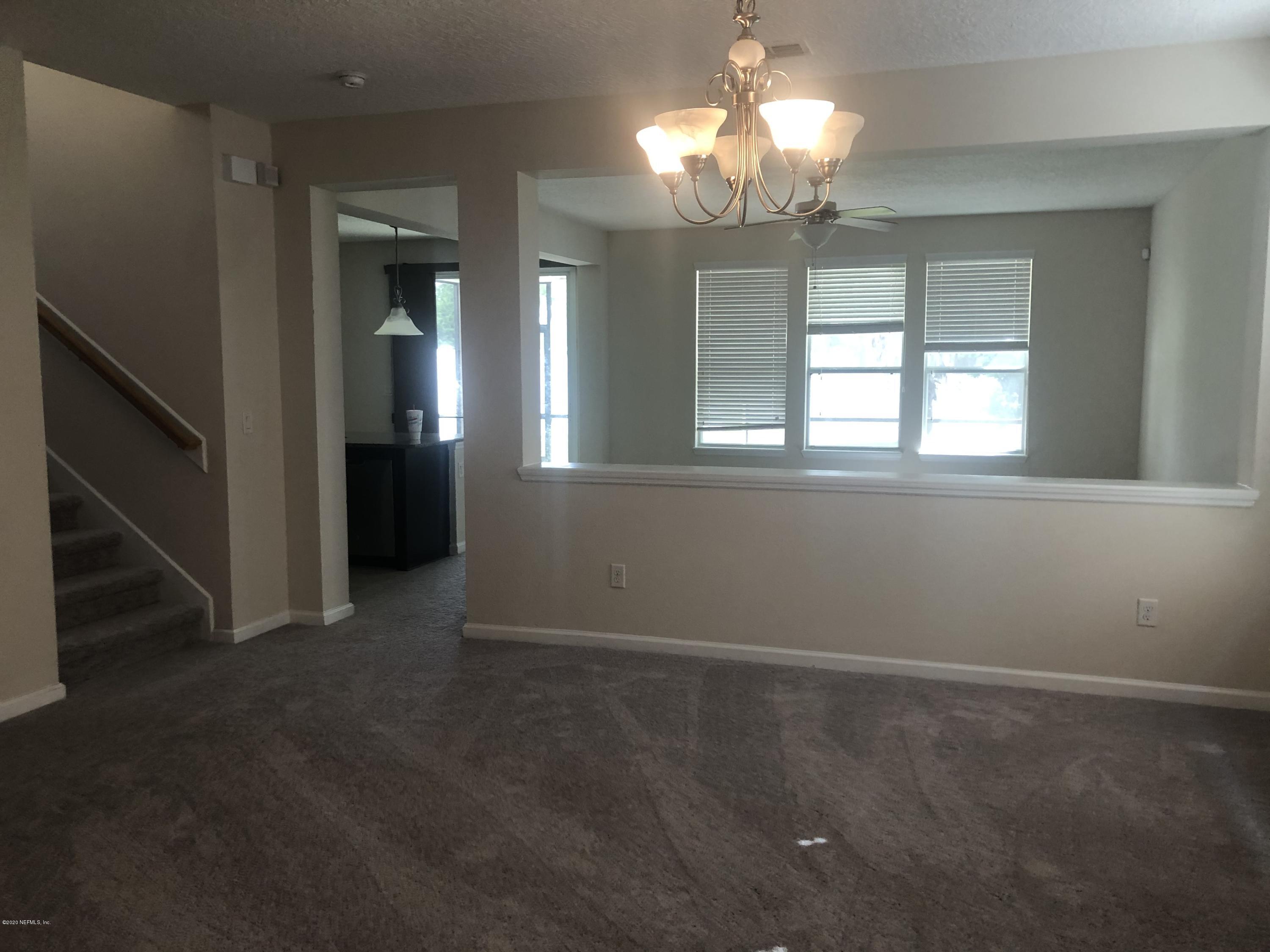 3782 Chasing Falls Road Orange Park, FL 32065 - Photo 2 of 22 en empty room with windows and chandelier