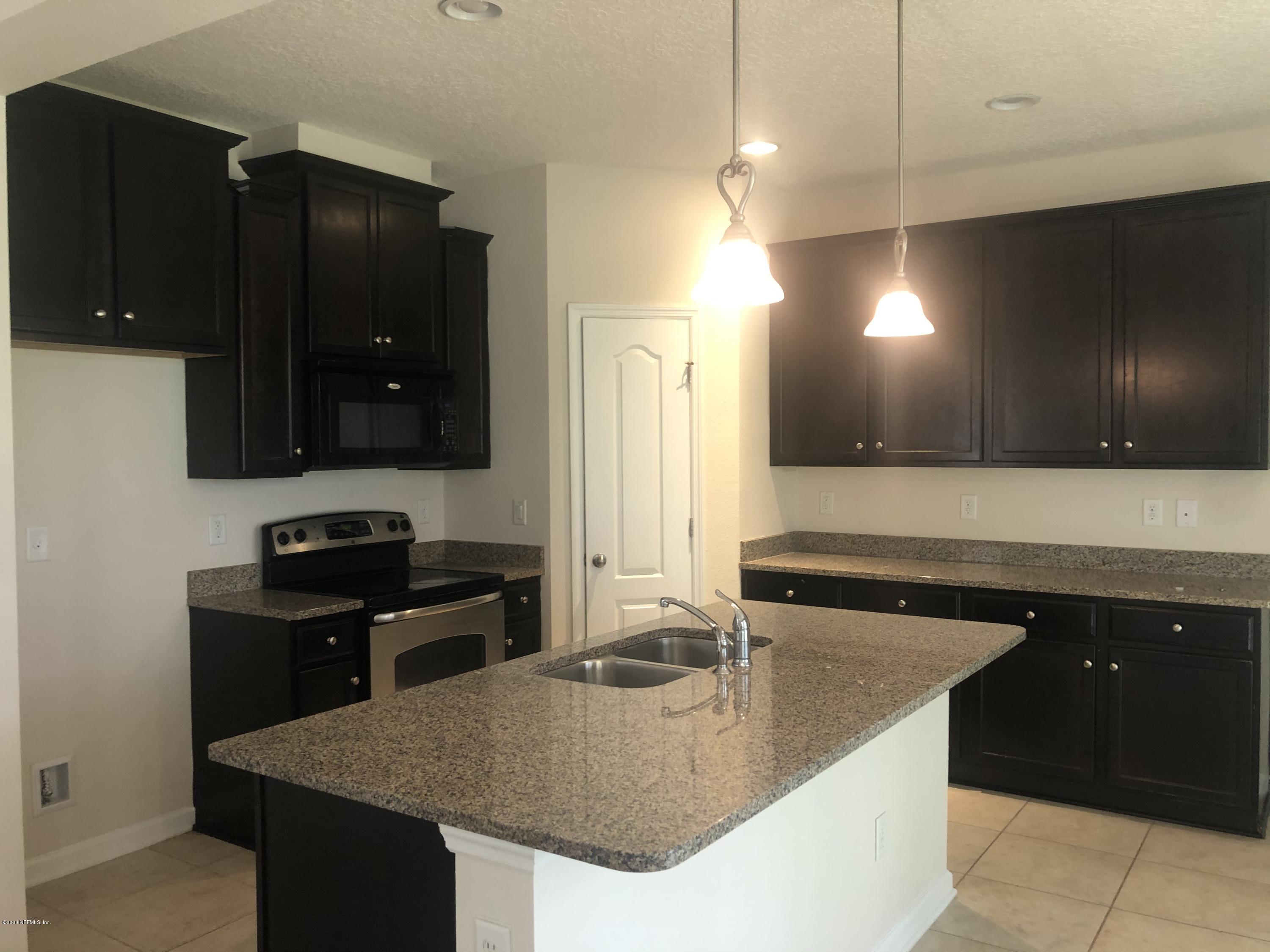 3782 Chasing Falls Road Orange Park, FL 32065 - Photo 5 of 22 a kitchen with granite countertop a sink a stove and cabinets