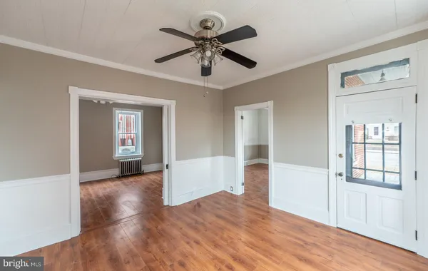 a view of empty room with wooden floor and ceiling fan