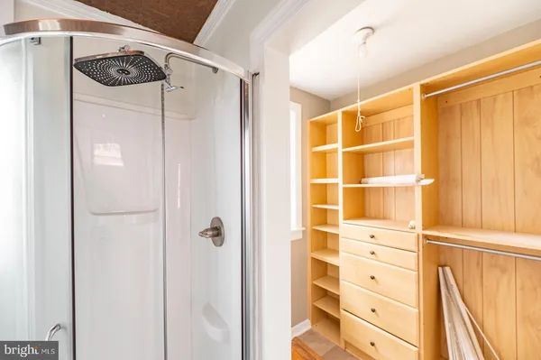 a view of walk in closet with empty racks