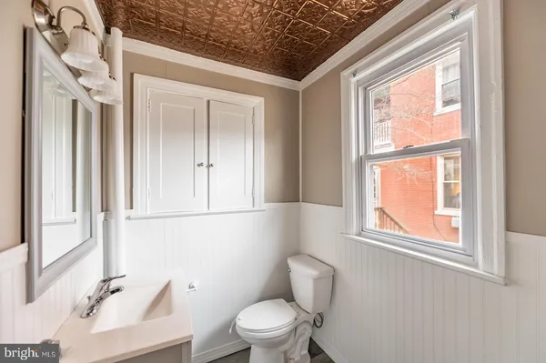 a bathroom with a toilet a sink and a window