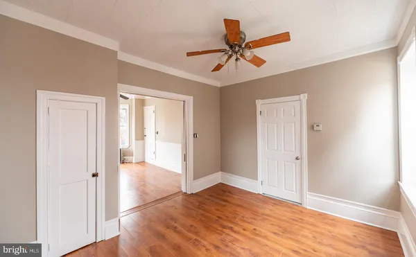 a view of a livingroom with a ceiling fan and wooden floor