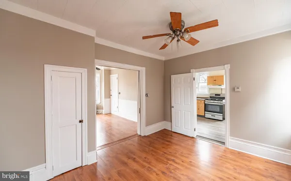 a view of a livingroom with wooden floor and a ceiling fan