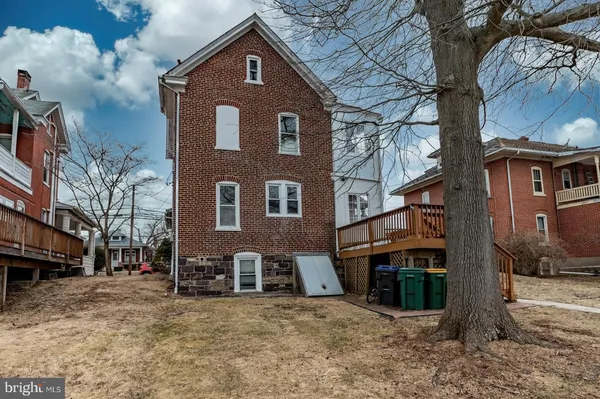 a front view of a house with a yard covered with snow