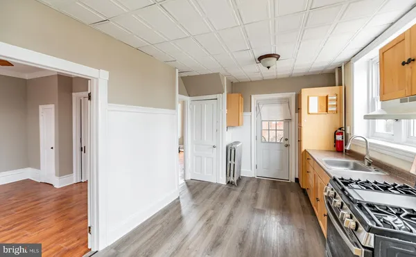 a view of a kitchen with a stove wooden floor and a window
