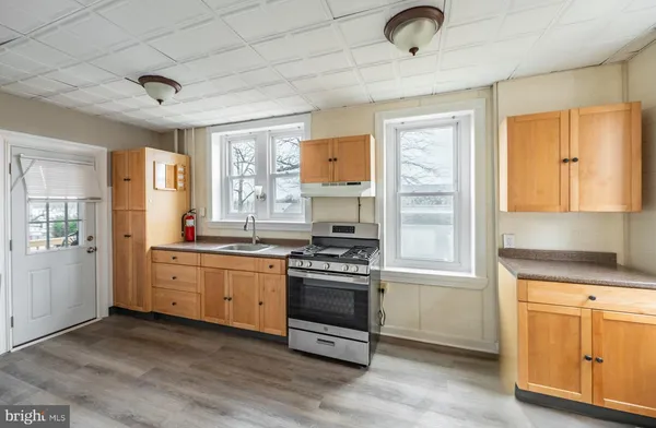a kitchen with granite countertop a stove a sink and a refrigerator