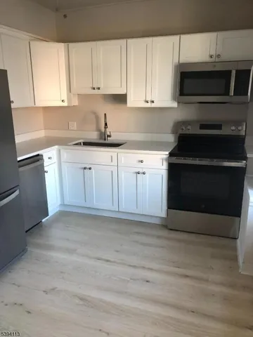 a kitchen with granite countertop a stove microwave and sink