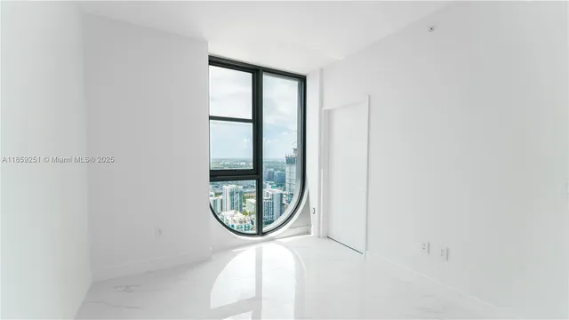 a large white room with kitchen view and a cabinets