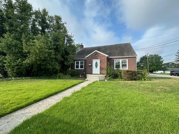 a front view of a house with a yard and green space