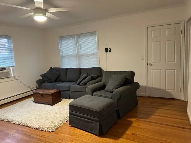 a living room with furniture and a hard wood floor